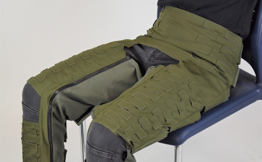 a seated figure wears Anti-G Trouser prototype