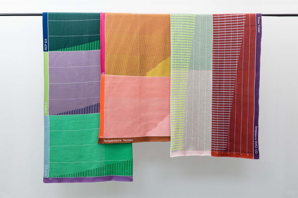 Colorful striped textiles hang on a rod.