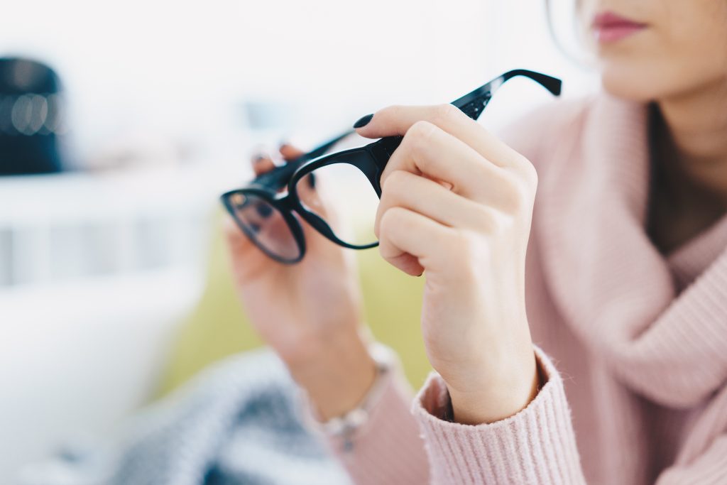 woman holding warby parker glasses