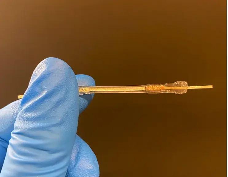 Flexible ribbon battery developed for smart textiles, held between gloved fingers